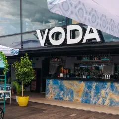 Warszawa knajpy z klimatem: bar VODA z niebieskim marmurowym blatem i butelkami ginu na wózku.