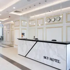 Eleganckie lobby hotelu Sky Kraków z marmurowym recepcjonistą i zegarami światowymi.