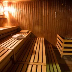 Drewniane ławy i kamienny piec w przytulnej czeskiej saunie. Czeska sauna co to? To relaks i gorąco!