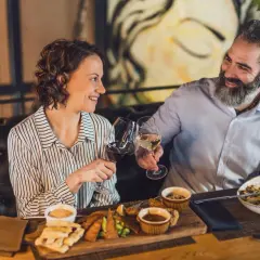 Para celebruje w najdroższej restauracji w Warszawie. Wznoszą toast winem, delektując się wykwintnym jedzeniem.