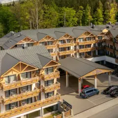 Nowoczesny hotel Platinum Mountain & Spa w otoczeniu lasu. Elegancka architektura z drewnianymi elementami i licznymi balkonami.
