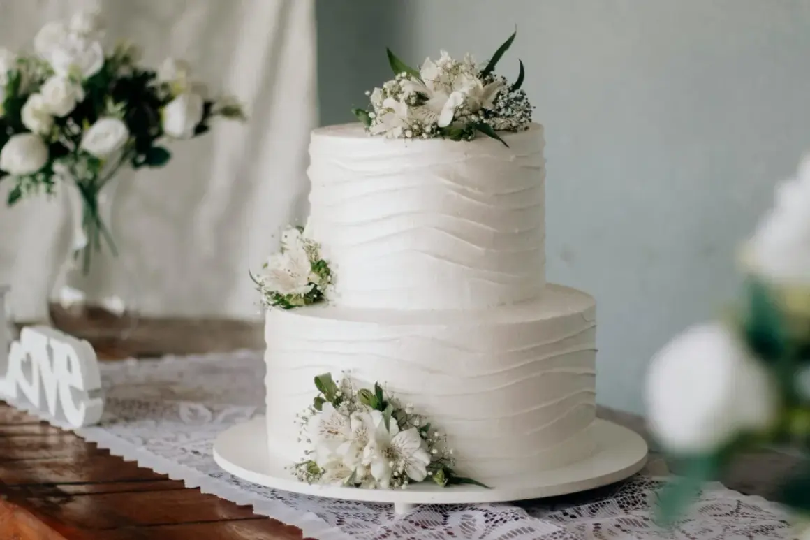 Elegancki tort weselny z białymi kwiatami. Idealny rozmiar, by zaspokoić głód na 40 osób.